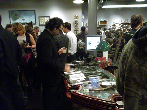 A gentleman checks out the artist catalog that sits on the Steampunk Executive Gear Desk, created by Dale Mathis