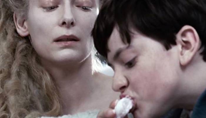 Edmund eats Turkish Delight under the watchful eye of the White Witch
