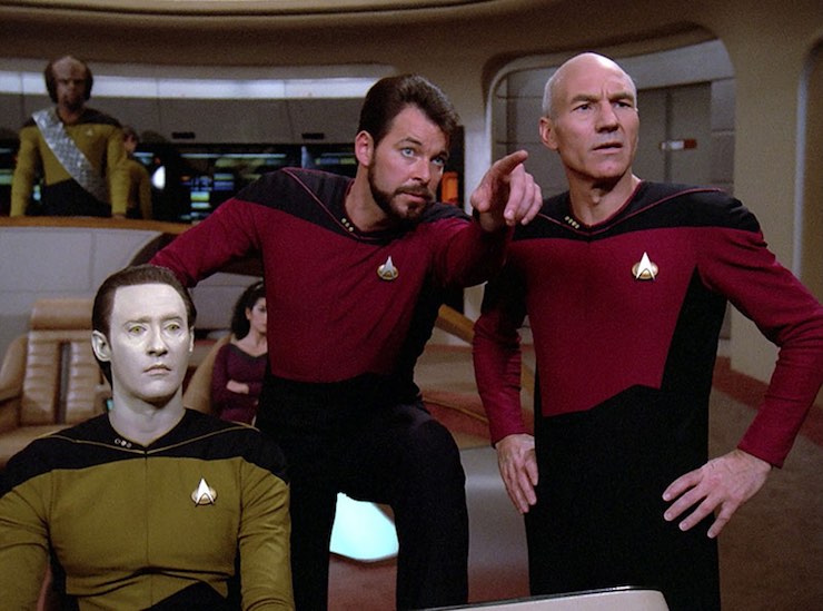 Image from Star Trek: The Next Generation showing Data, Riker, and Picard on the bridge of the Enterprise. Worf stands in the background.