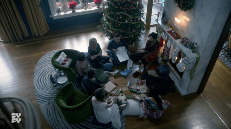 Scene from The Magicians, with the group sitting beneath a Christmas tree