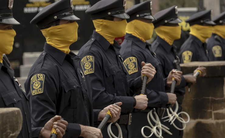 Scene from Watchmen with masked police officers