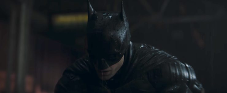 Robert Pattinson as Batman, crouched, in The Batman