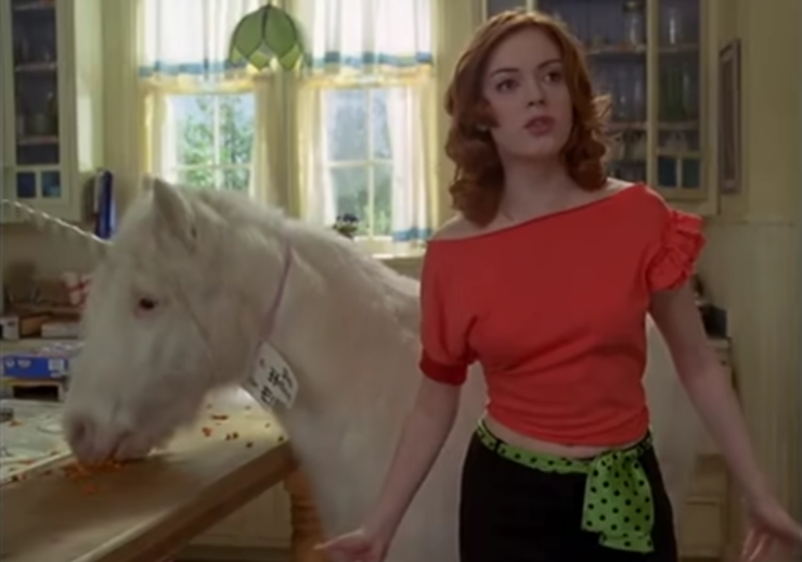 Paige (Rose McGowan) stands beside a unicorn in a scene from Charmed