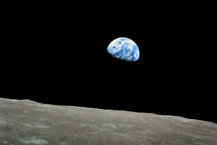 Photo of the earth rising over the surface of the moon