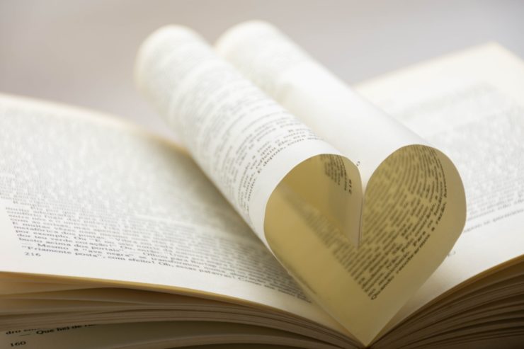 Photograph of an open book with two pages positioned to form a heart