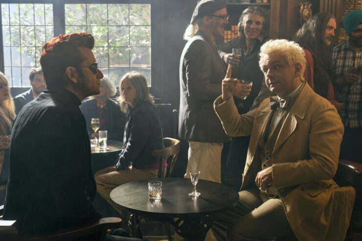 David Tennant (Crowley) and Michael Sheen (Aziraphale) seated at a table in a pub