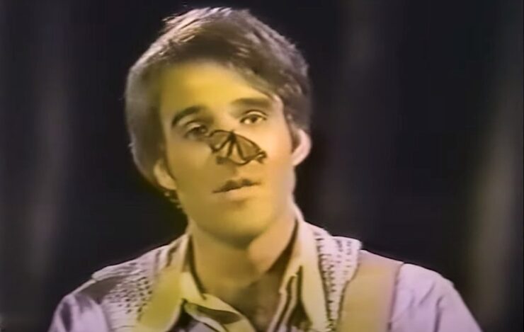 A butterfly perches on Steve Martin's nose during a banjo performance. 