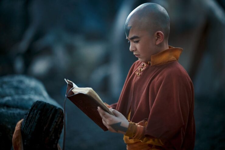 Image from Netflix's Avatar: The Last Airbender depicting Aang holding an open book.