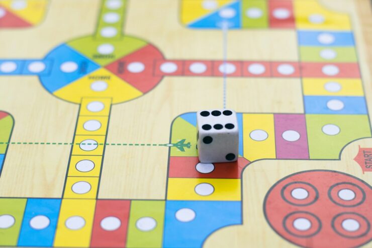 Close-up photograph of a generic board game and a six-sided die.