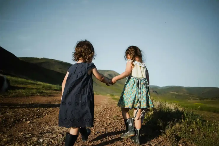 Two children holding hands as friends