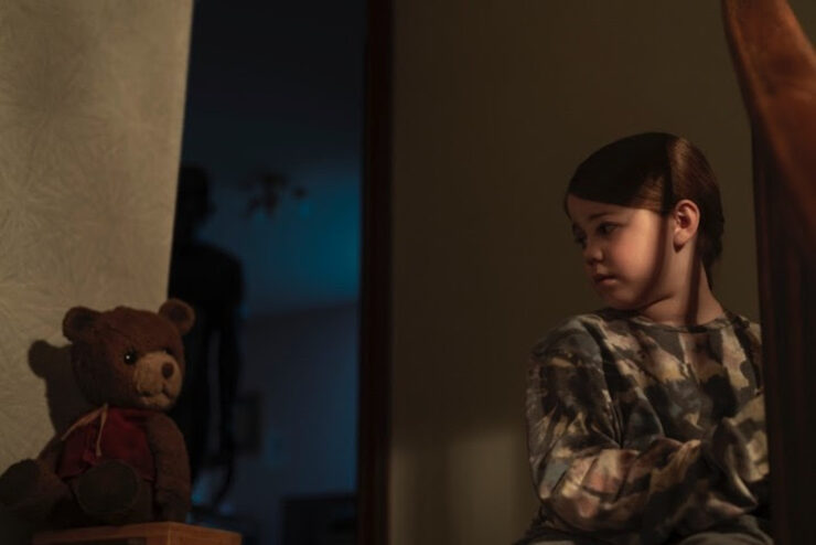 Little girl next to teddy bear in Imaginary trailer