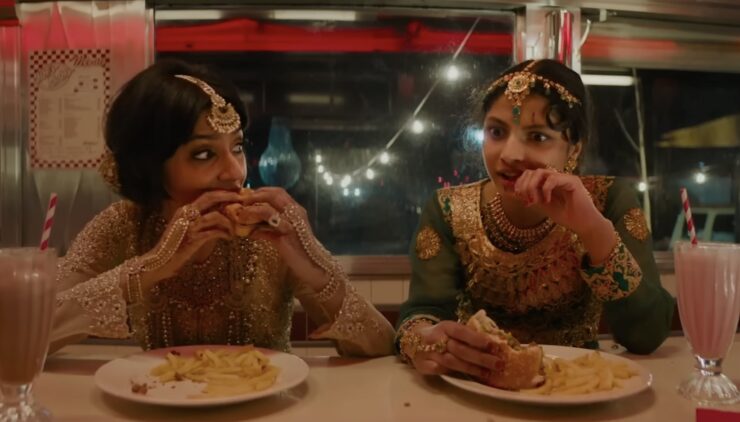 Lena and Ria eating burgers and milkshakes at a diner in Polite Society