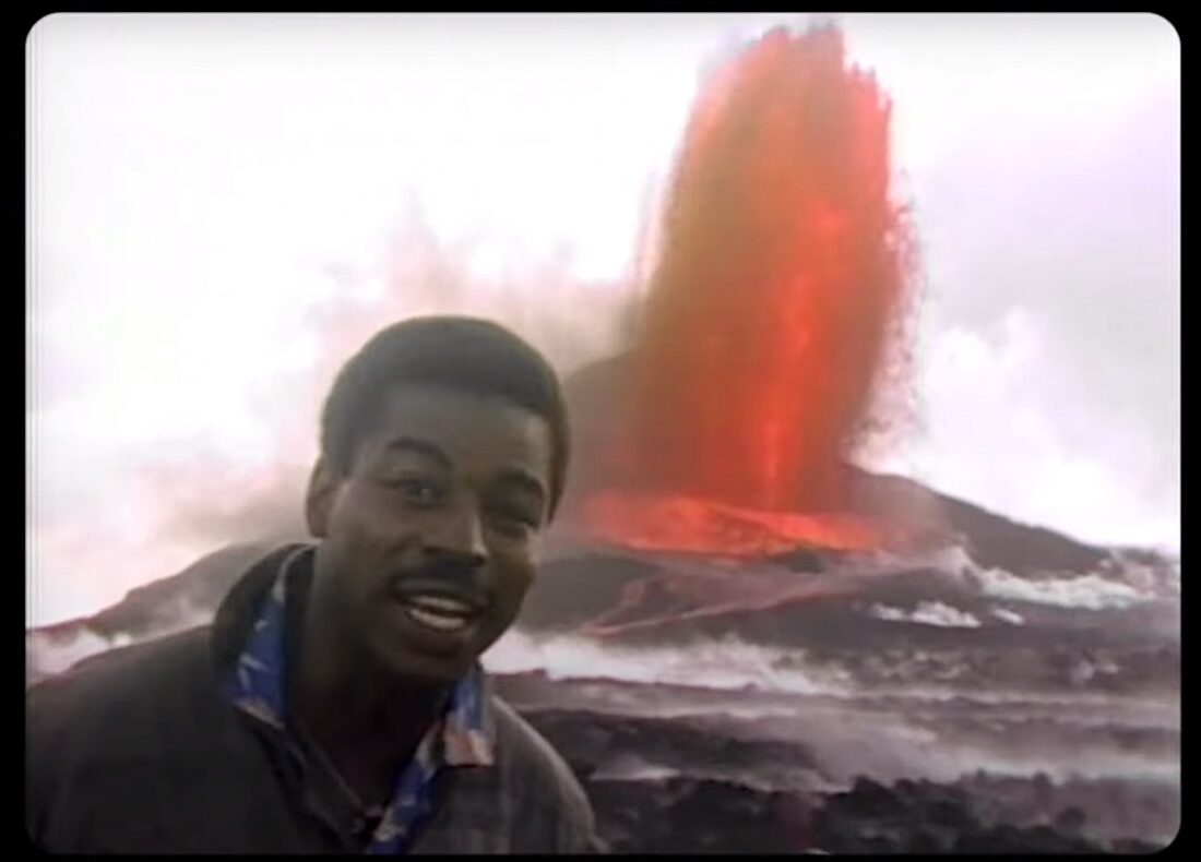 Reading Rainbow host LeVar Burton stands in front of an erupting volcano in Hawaii.