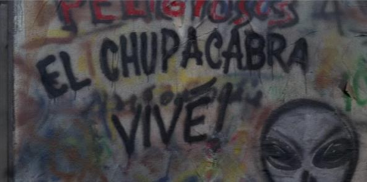 A Screenshot of The X-Files, showing a wall with graffiti saying "El chupacabra vive!"