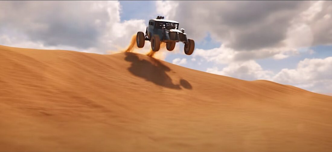 A monster truck rises over the Wasteland dunes in a scene from Furiosa: A Mad Max Saga