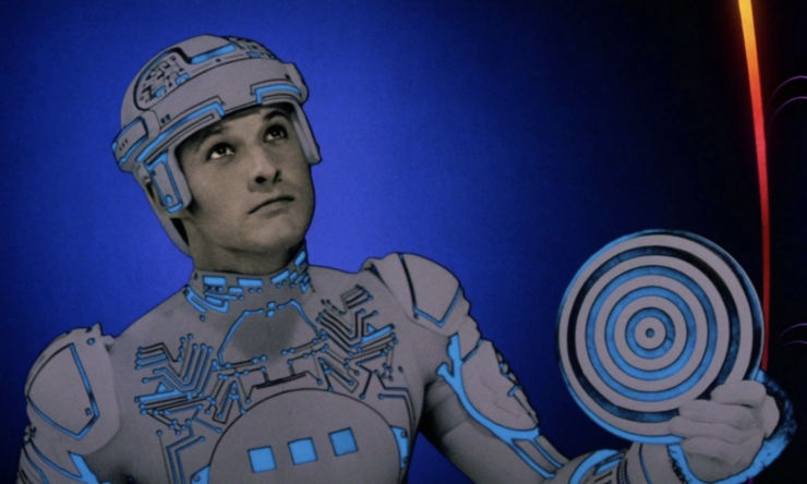 A scene from Tron (1982) in which Tron (Bruce Boxleitner) holds an Identity Disc