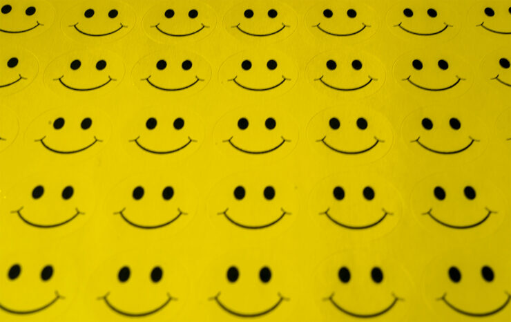 Close-up photo of a sheet of yellow smiley face stickers