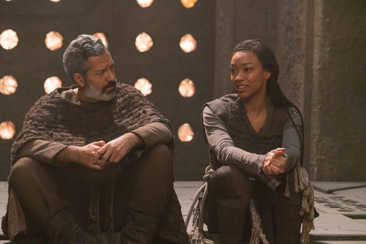 Burnham sits with the leader of a pre-warp society in a scene from Star Trek: Discovery “Whistlespeak”