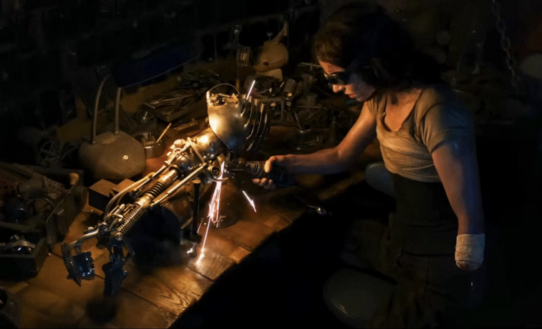 Furiosa (Anya Taylor-Joy) builds her prosthetic arm in Furiosa: A Mad Max Saga