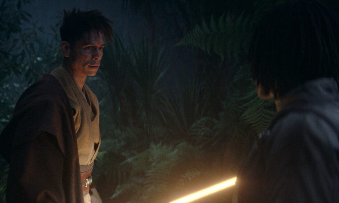Yord Fandar (Charlie Barnett) and Osha (Amandla Stenberg) speaking in a dark forest in Lucasfilm's THE ACOLYTE, season one, "Night."