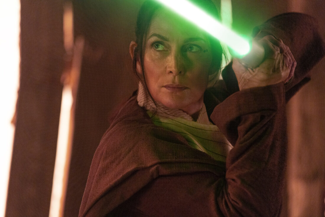 Jedi Master Indara (Carrie-Anne Moss) in Lucasfilm's THE ACOLYTE, lightsaber drawn, Episode 1, "Lost / Found"