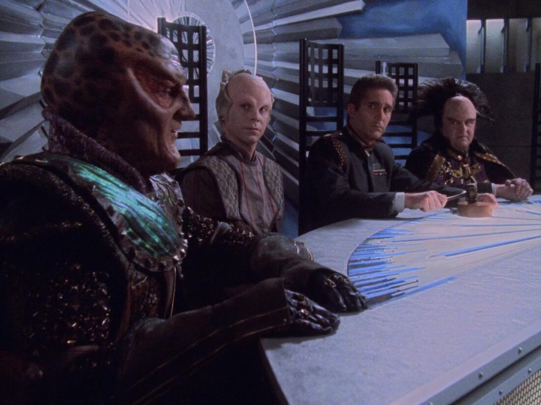 G'Kar, Lennier, Sinclair, and Mollari sit on the council in a scene from Babylon 5 "Deathwalker"