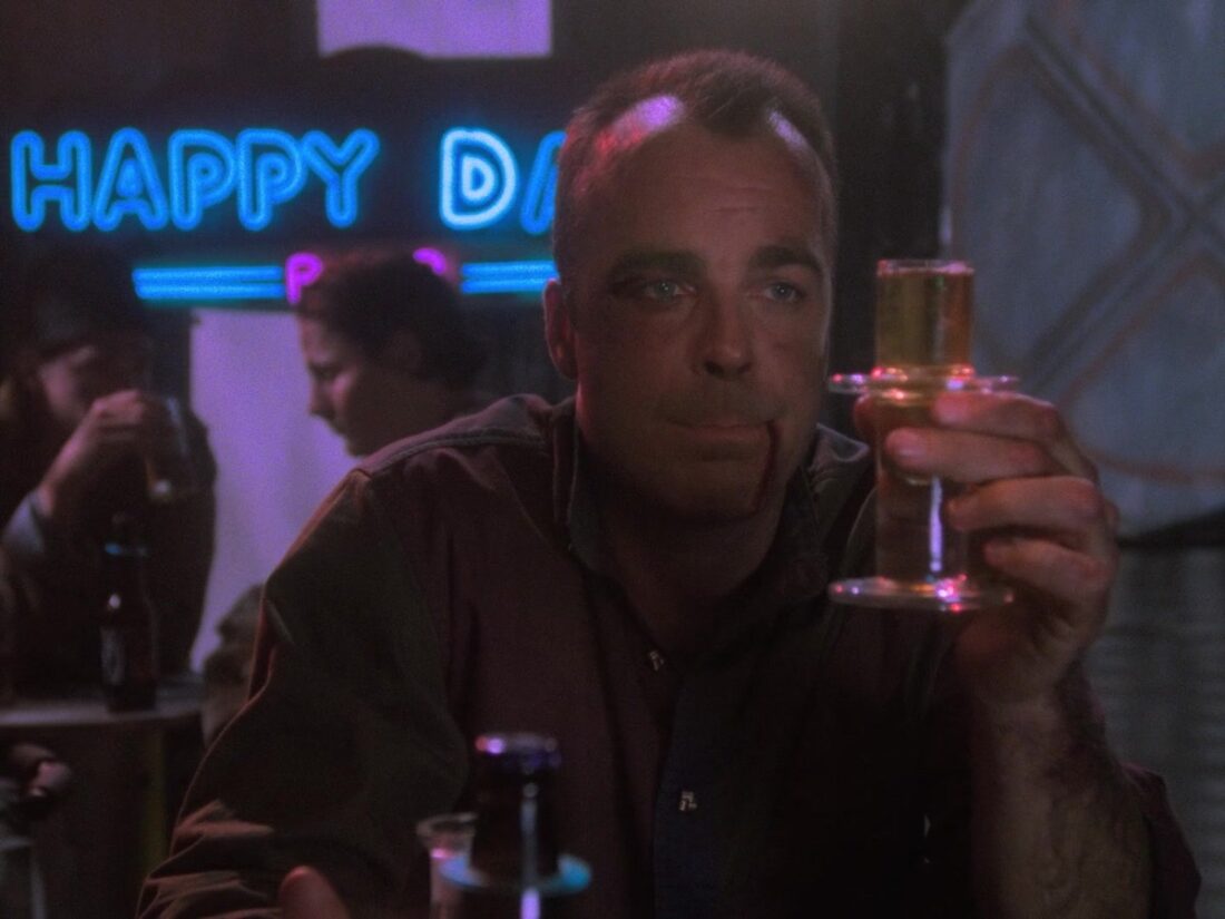 Garibaldi holds a drink in a scene from Babylon 5 "Survivors"