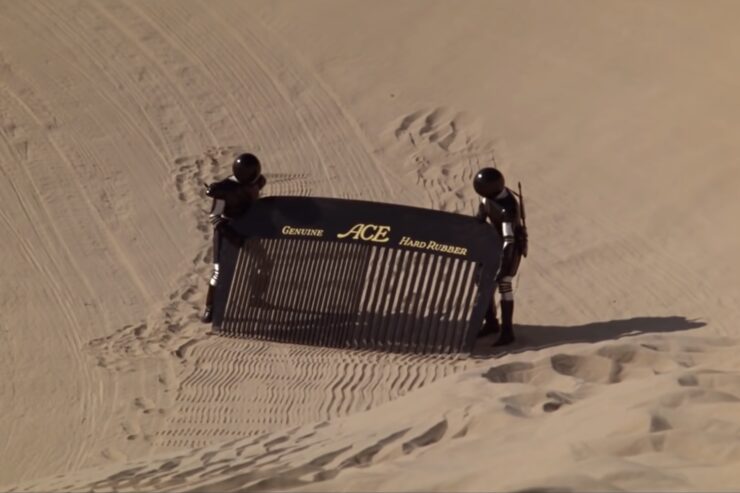 Two not-stormtroopers literally combing the desert with a large fine-toothed comb