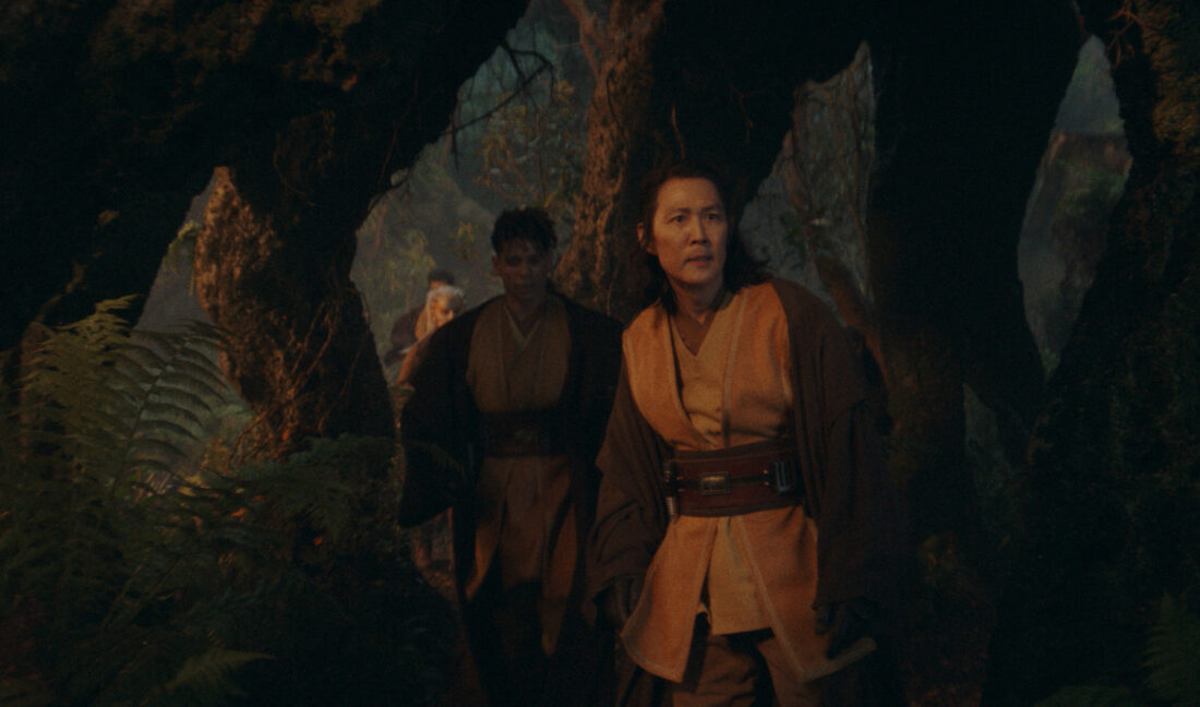 Master Sol (Lee Jung-jae), Yord Fandar (Charlie Barnett) and Jedi Padawan Jecki Lon (Dafne Keen) in Lucasfilm's THE ACOLYTE, season one, Sol looking into the darkness