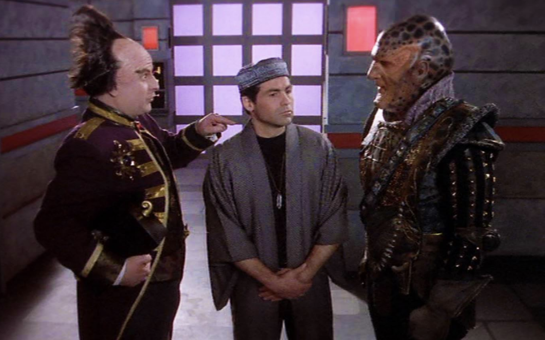 Mollari and G'Kar stand with an unnamed human character in Babylon 5 "Signs and Portents"