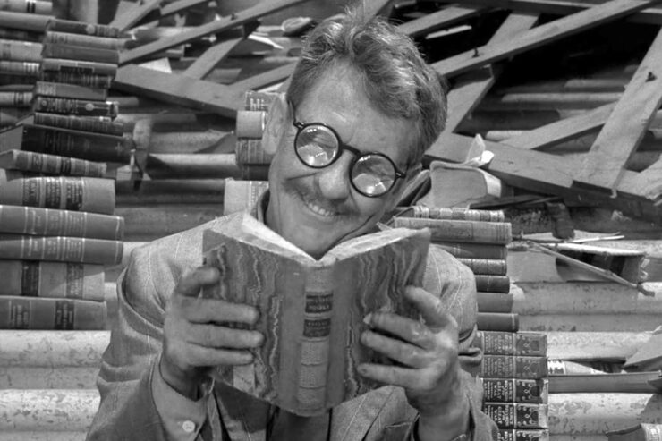 A scene from The Twilight Zone episode "Time Enough at Last": Harold Bemis (Burgess Meredith) reads a book with a smile on his face.