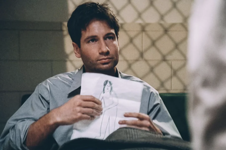 Fox Mulder (David Duchovny) holds a crude drawing of a humanoid figure in The X-Files episode "The Jersey Devil"