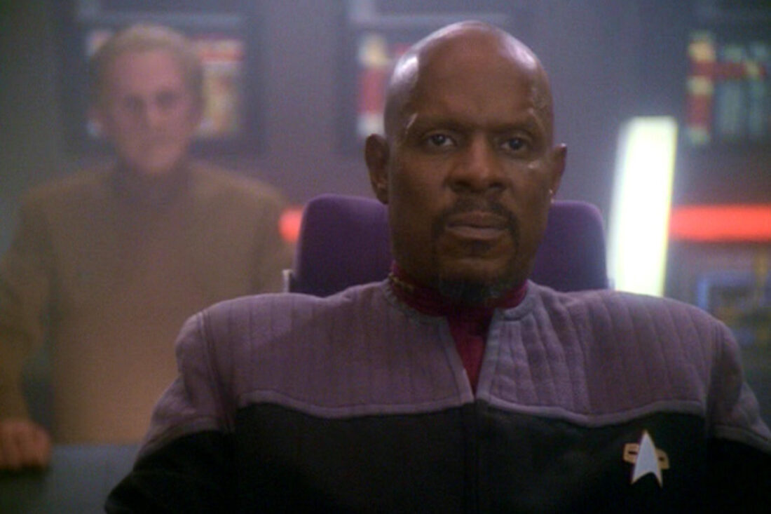 Odo stands behind Captain Sisko in a scene from Star Trek: Deep Space Nine "What You Leave Behind"