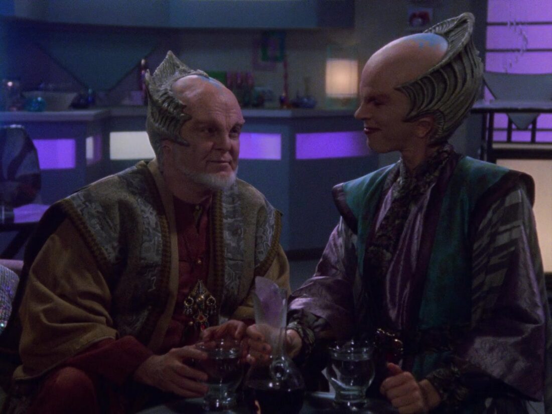 A scene from Babylon 5 "A Voice in the Wilderness, Part 1": Draal and Delenn sit and talk over drinks.