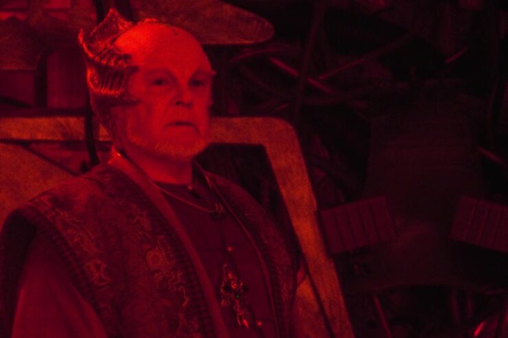 A scene from Babylon 5 "A Voice in the Wilderness, Part 2": Draal stands in a red-lit room