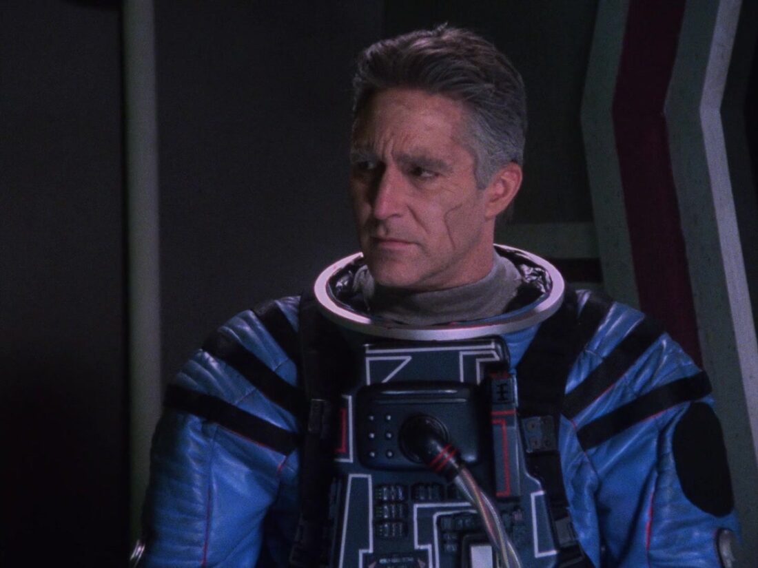 A scene from Babylon 5 "Babylon Squared": An older Sinclair stands in an EVA suit