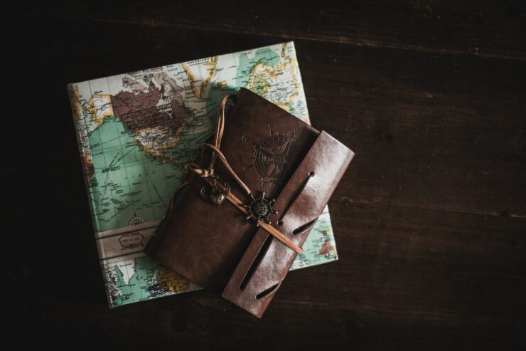 leather bound travel journal and a square book of maps