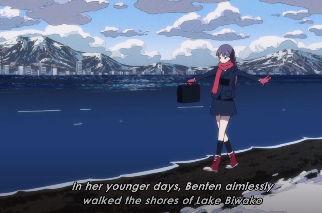 A scene from the anime series The Eccentric Family: Benten walks along the shore of a lake in winter. The subtitles read: "In her younger days, Benten aimlessly walked the shores of Lake Biwako."