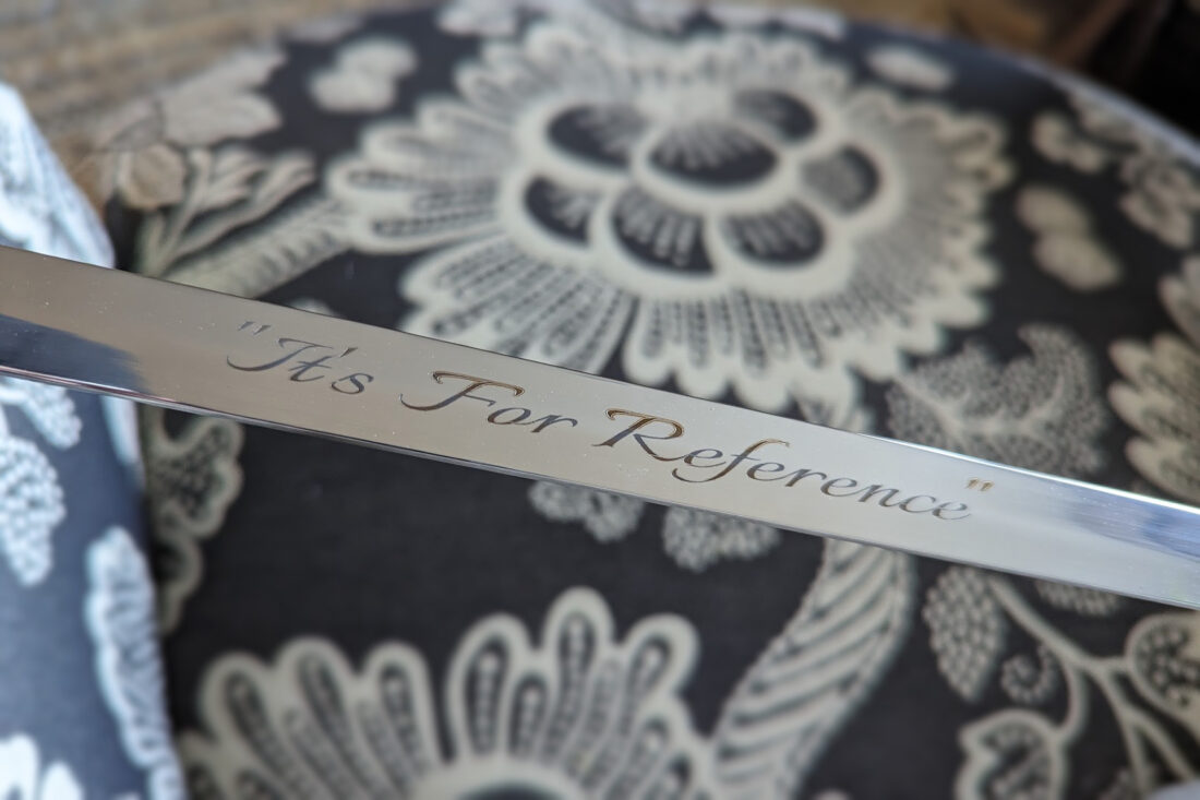 Photo of a sword blade engraved with the inscription "It's For Reference"