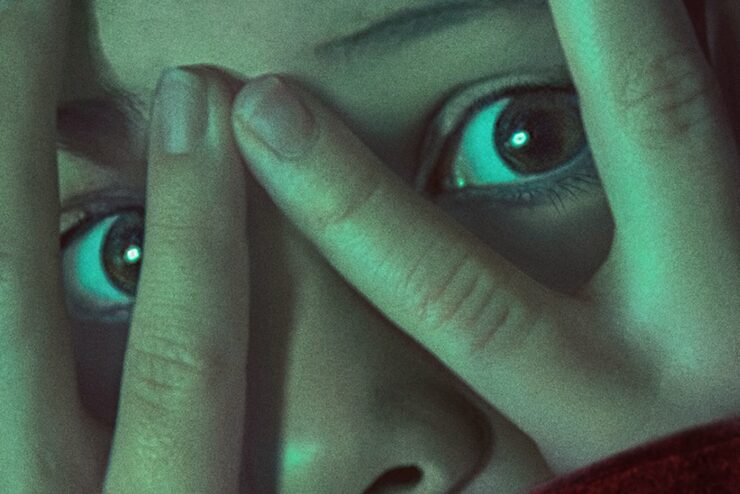 Scared eyes looking through fingers from Wolf Man poster