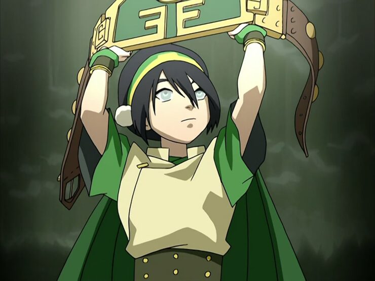 Toph holding her victor's belt aloft in "The Blind Bandit" on Avatar: The Laster Airbender