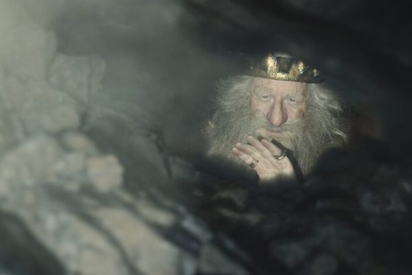 Peter Mullan as King Durin III looking up through a shaft of light in Lord of the Rings: The Rings of Power, "Halls of Stone"