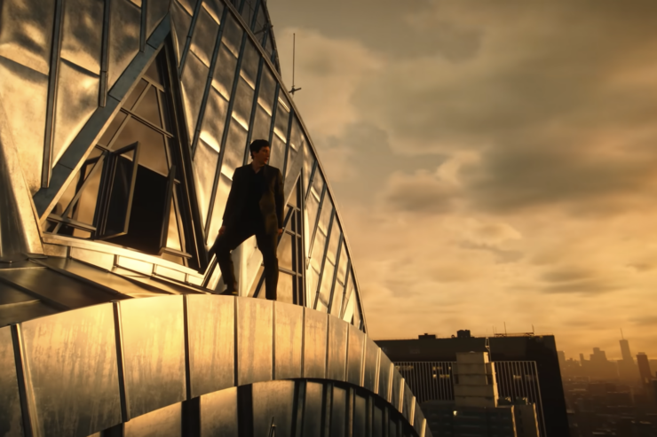 Adam Driver stands on the ledge of an art deco building in a scene from Megalopolis