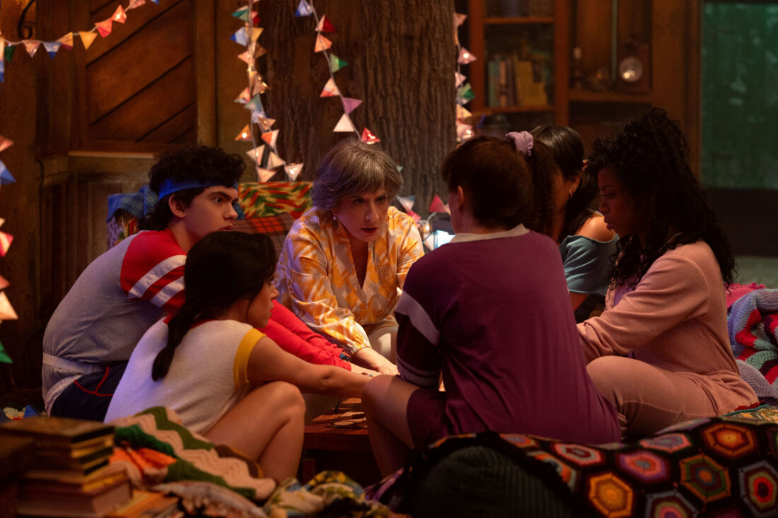 L-R) Teen (Joe Locke), Rio Vidal (Aubrey Plaza), Lilia Calderu (Patti LuPone), Agatha Harkness (Kathryn Hahn), Alice Wu-Gulliver (Ali Ahn) and Jennifer Kale (Sasheer Zamata) surrounding a Ouija board in Agatha All Along, episode 5