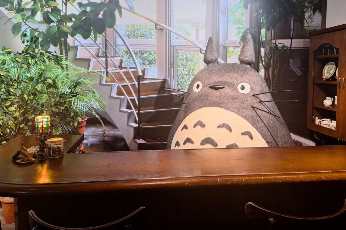 A life-size figure of Totoro stands behind a counter at Ghibli Park