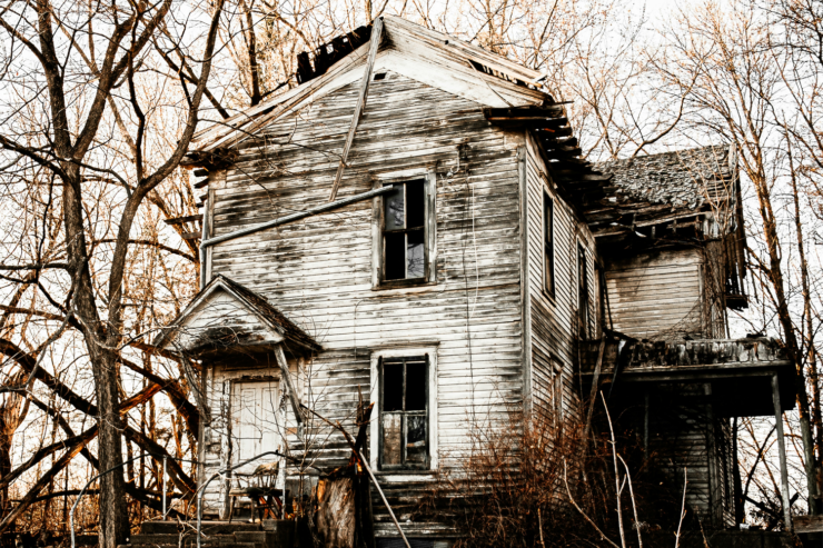 An abandoned white and black wooden house