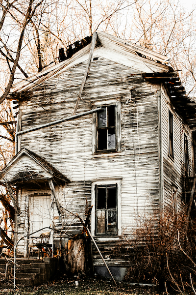 An abandoned white and black wooden house