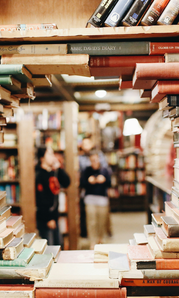 A bookstore seen through a circular gap in a bookshelf