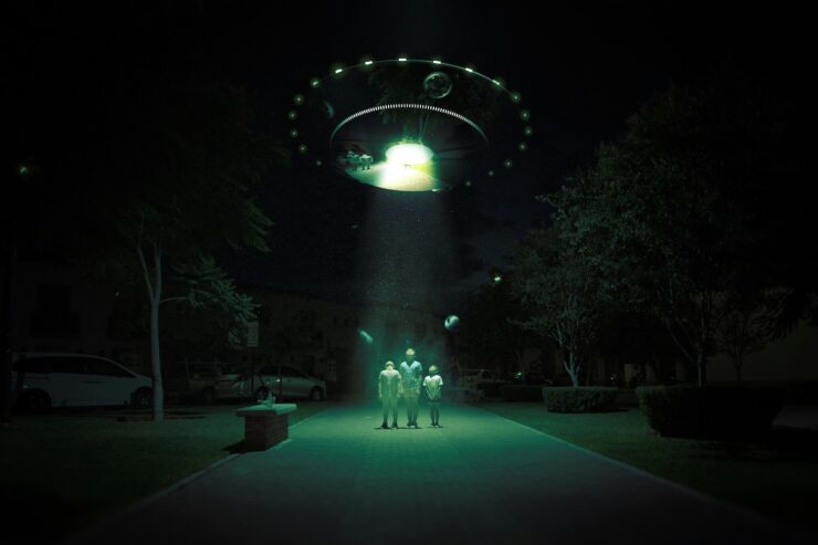 Digitally manipulated photo of a UFO appearing above three figures standing on a wide path