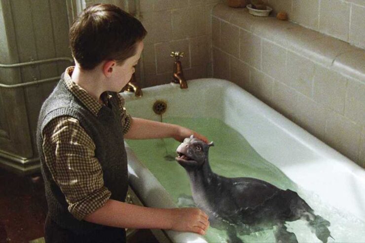 Angus (Alex Etel) sits beside a bathtub containing a juvenile water horse, in a scene from The Water Horse (2007)